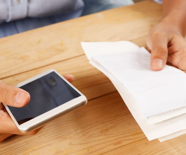 Woman paying her bills with her cell phone using PayPulse